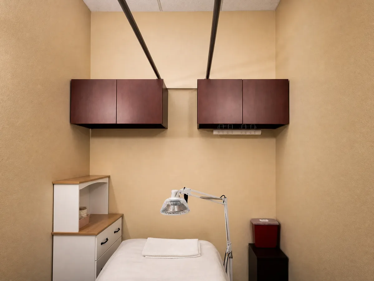 Quiet treatment room with soft wall light and framed art